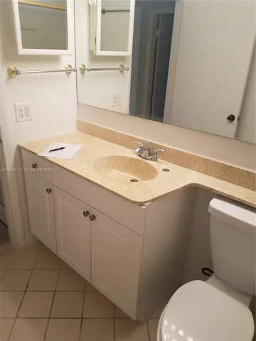 a bathroom with a sink a toilet and mirror