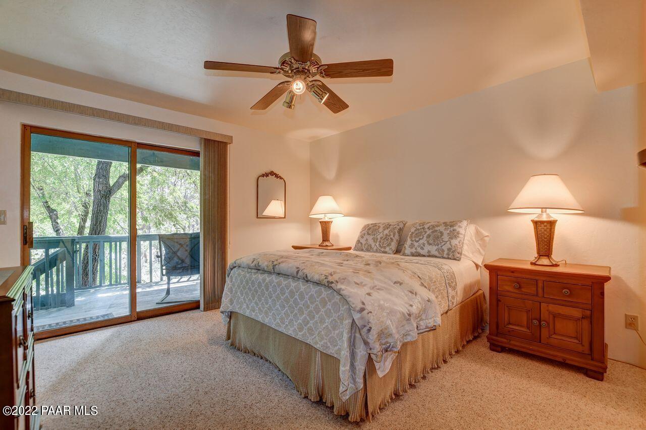 1219 Timber Point North Prescott, AZ 86303 - Photo 17 of 33 a bedroom with a bed a chandelier and a large window