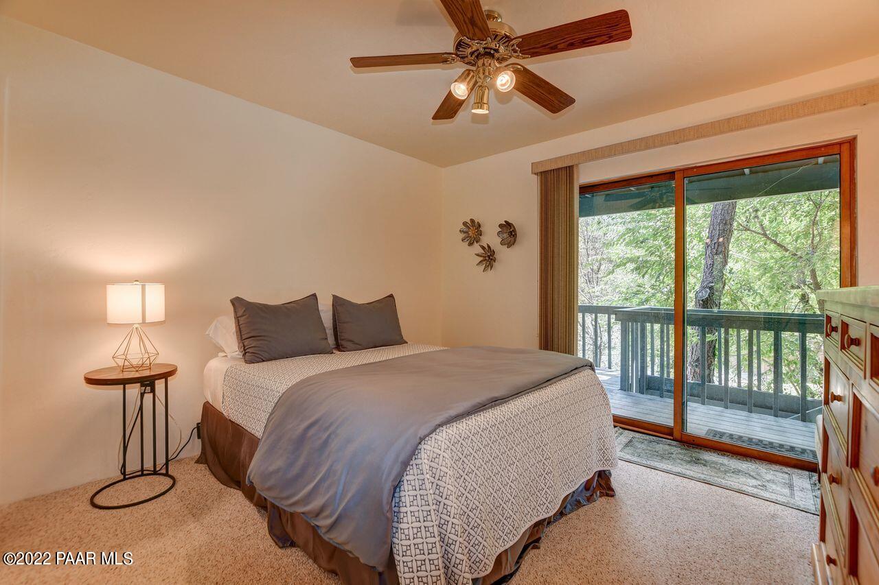 1219 Timber Point North Prescott, AZ 86303 - Photo 20 of 33 a spacious bedroom with a bed and a chandelier
