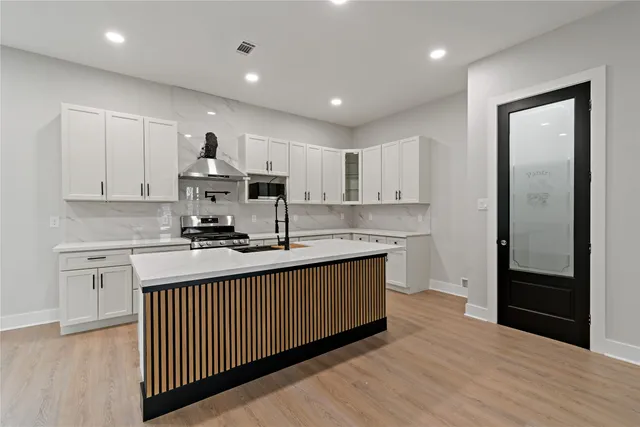 a kitchen with stainless steel appliances granite countertop a sink stove and cabinets