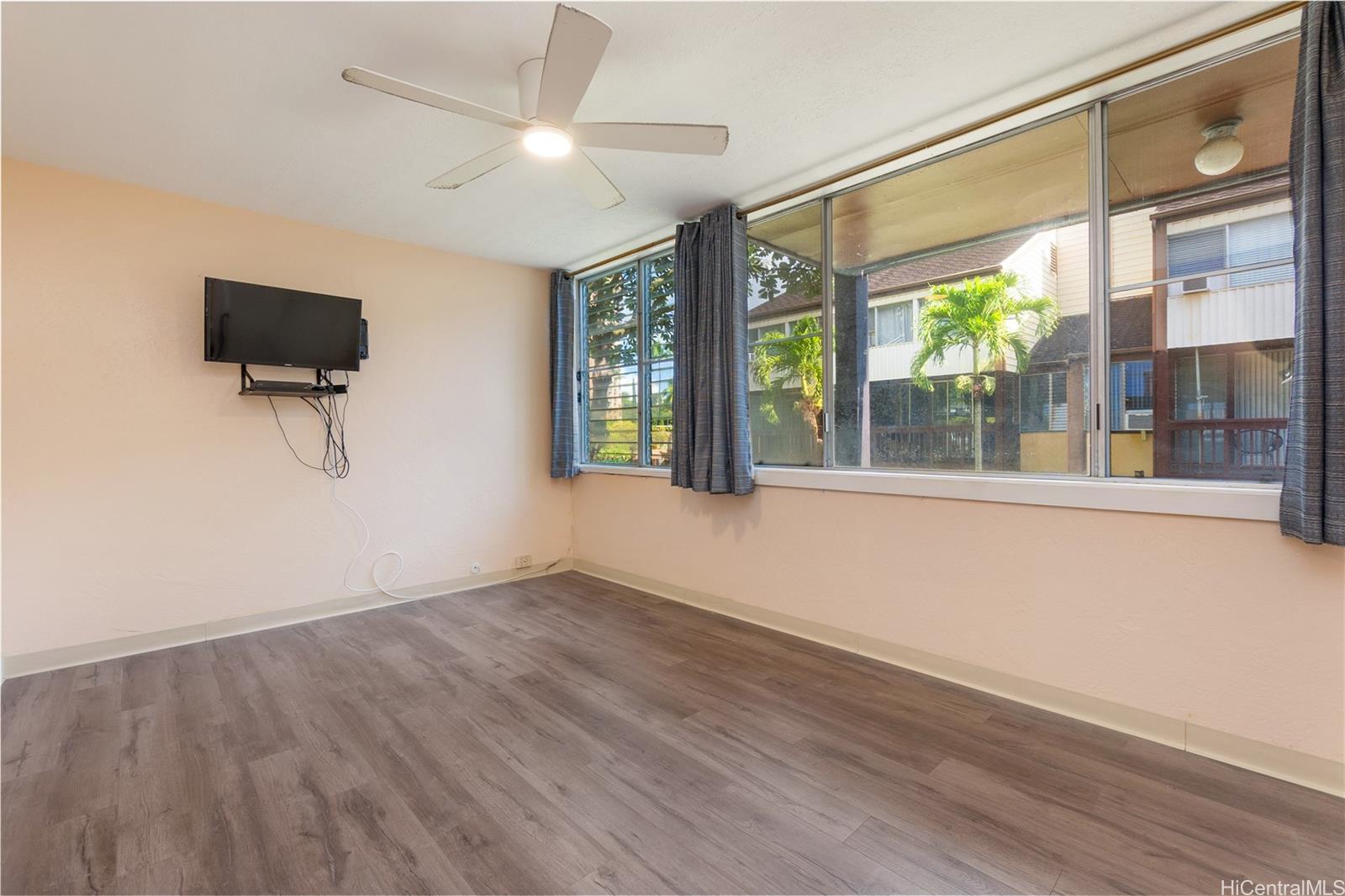 98-360 Koauka Loop, Unit 243 Aiea, HI 96701 - Photo 13 of 25 a view of an empty room with a window and wooden floor