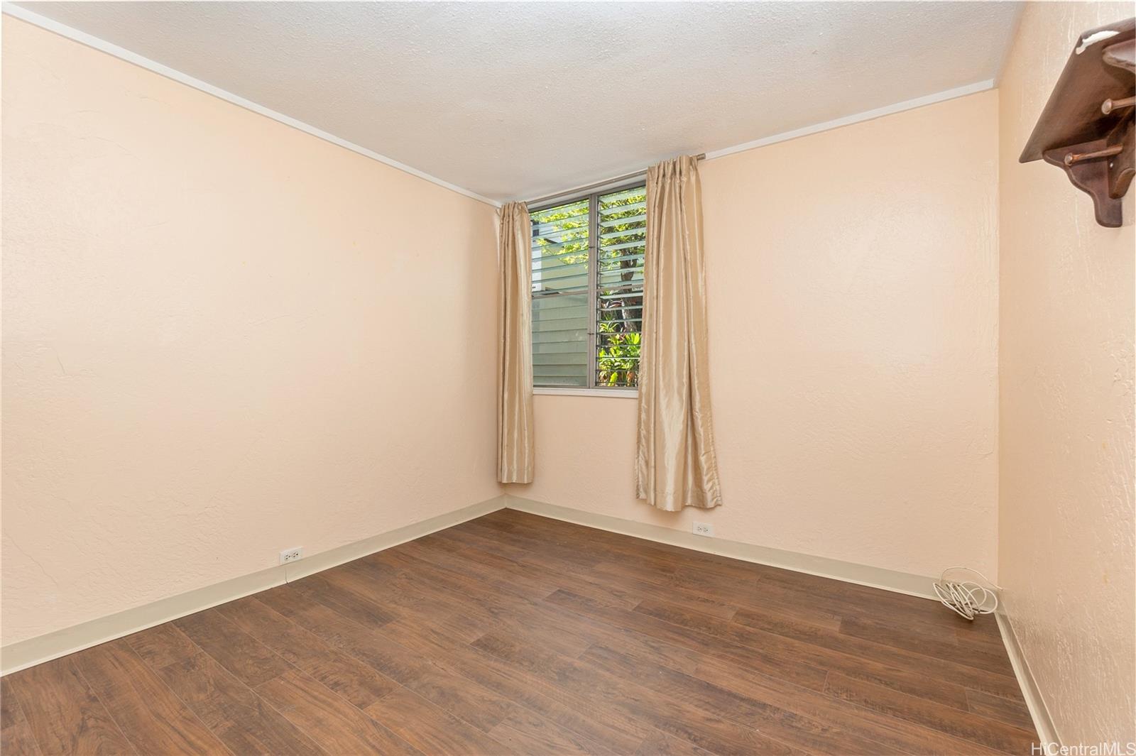 98-360 Koauka Loop, Unit 243 Aiea, HI 96701 - Photo 17 of 25 an empty room with wooden floor and windows