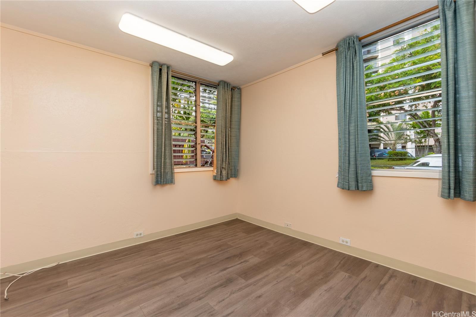 98-360 Koauka Loop, Unit 243 Aiea, HI 96701 - Photo 18 of 25 an empty room with wooden floor and windows