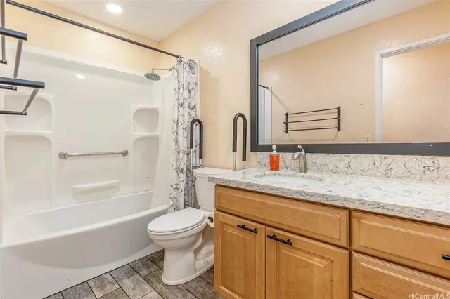 a bathroom with a granite countertop sink toilet and shower