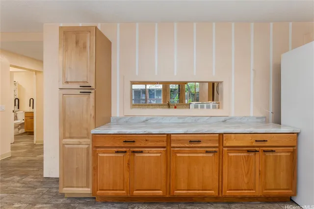 a kitchen with granite countertop a refrigerator and cabinets