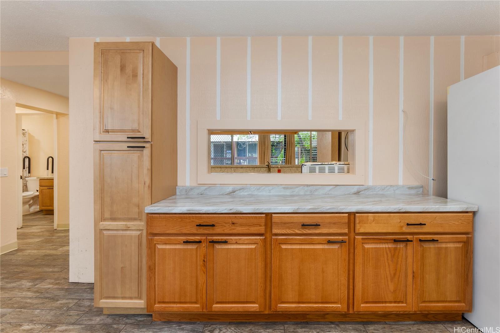 98-360 Koauka Loop, Unit 243 Aiea, HI 96701 - Photo 3 of 25 a kitchen with granite countertop a refrigerator and cabinets