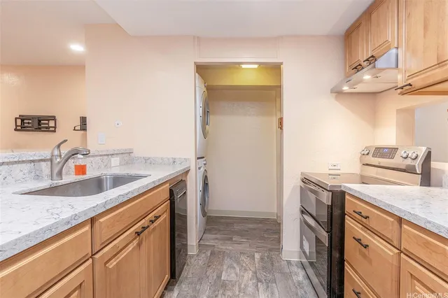 a kitchen with granite countertop a sink a stove and cabinets