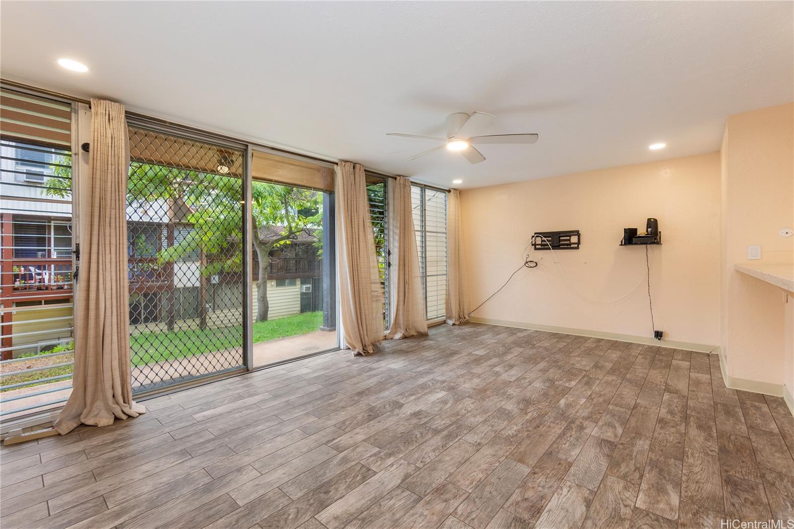 98-360 Koauka Loop, Unit 243 Aiea, HI 96701 - Photo 9 of 25 a view of an empty room with wooden floor and a ceiling fan