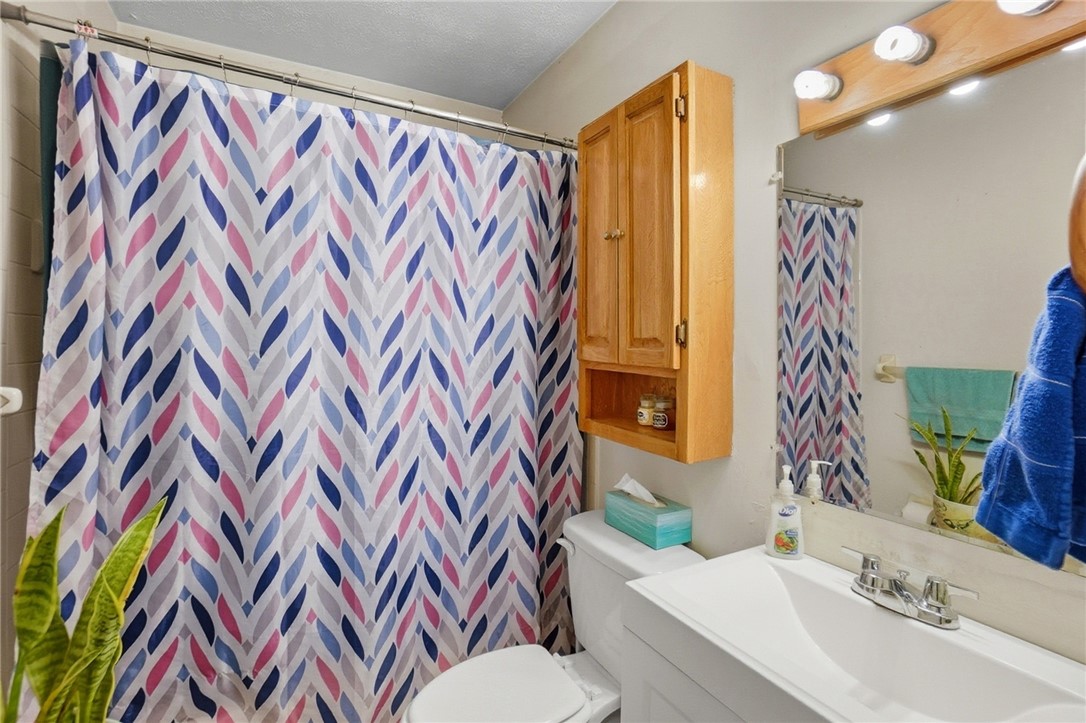 4780 Old Salem Road Englewood, OH 45322 - Photo 14 of 30 This bathroom features a sleek vanity and a shower with a vibrant curtain.
