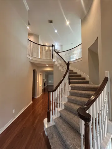 a view of a livingroom with a chandelier fan and kitchen view