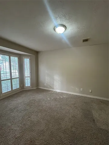 a large kitchen with kitchen island granite countertop a stove a sink a refrigerator dining table and chairs