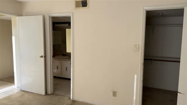 a view of walk in closet with empty racks