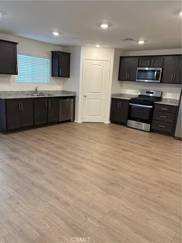a large kitchen with stainless steel appliances granite countertop a stove and a sink