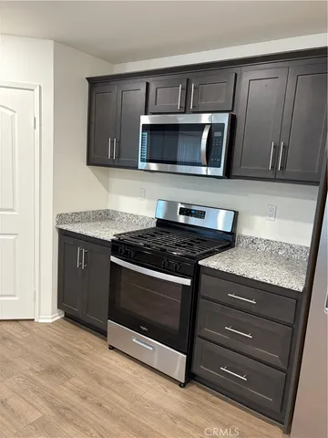 a kitchen with granite countertop a stove and a microwave