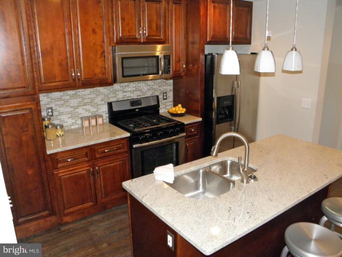 3960 S Street Southeast Washington, DC 20020 - Photo 13 of 27 a kitchen with granite countertop a sink cabinets and stainless steel appliances