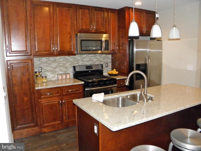 3960 S Street Southeast Washington, DC 20020 - Photo 3 of 27 a kitchen with stainless steel appliances granite countertop a sink a microwave refrigerator and stove