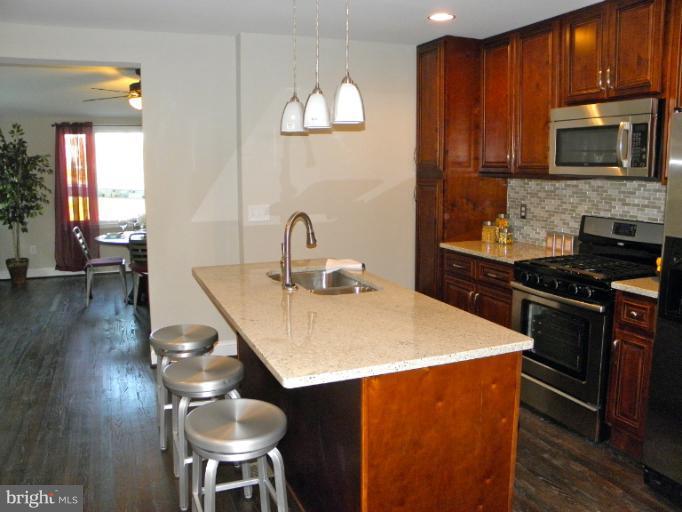 3960 S Street Southeast Washington, DC 20020 - Photo 23 of 27 a kitchen with stainless steel appliances a dining table and chairs