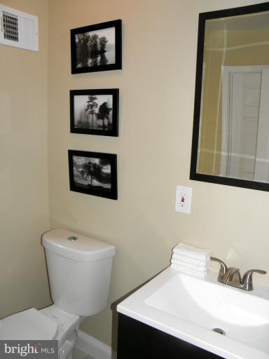 3960 S Street Southeast Washington, DC 20020 - Photo 10 of 27 a bathroom with a toilet a sink and a mirror