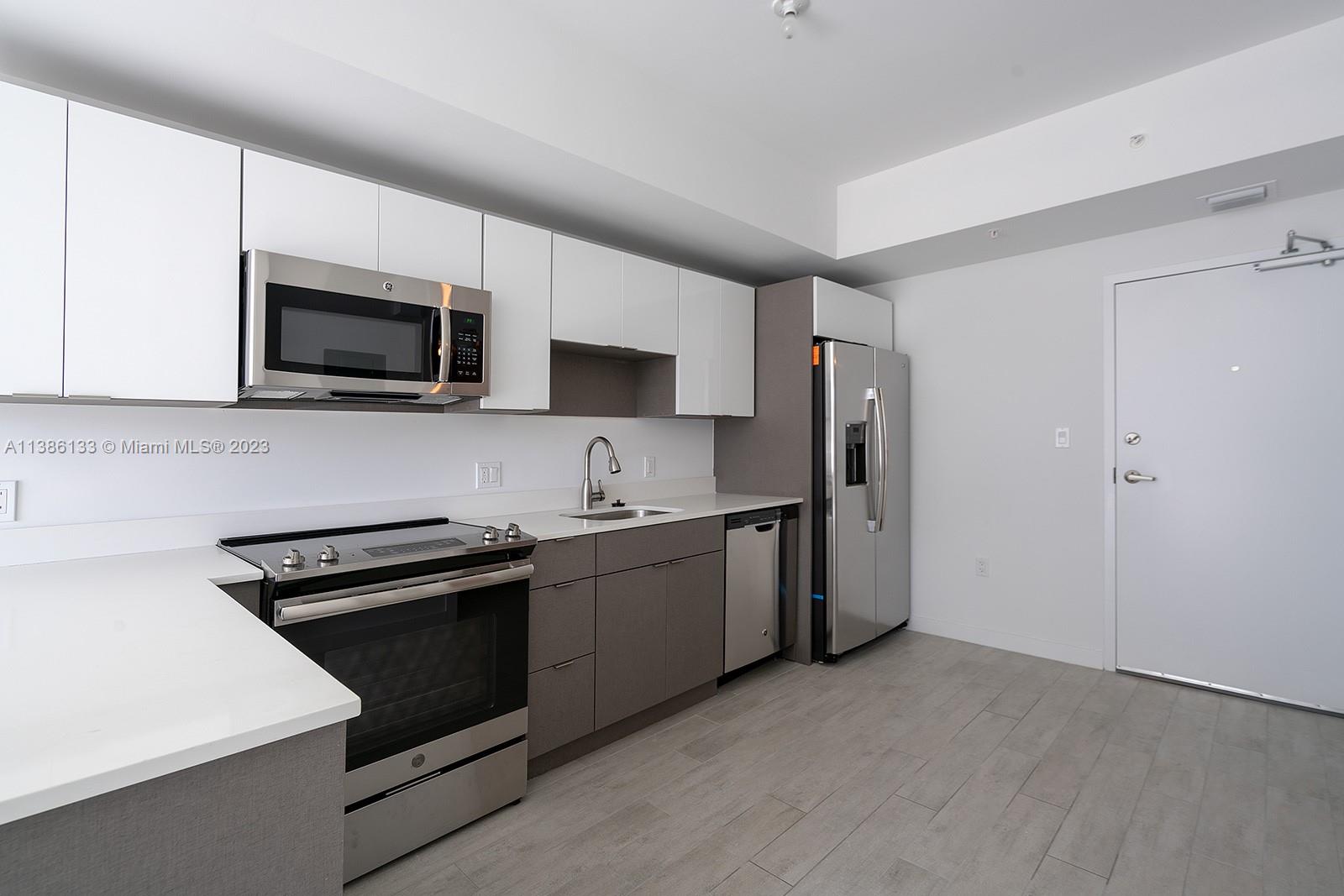 321 Northeast 26th Street, Unit 615 Miami, FL 33137 - Photo 6 of 15 a kitchen with stainless steel appliances a stove microwave sink and refrigerator