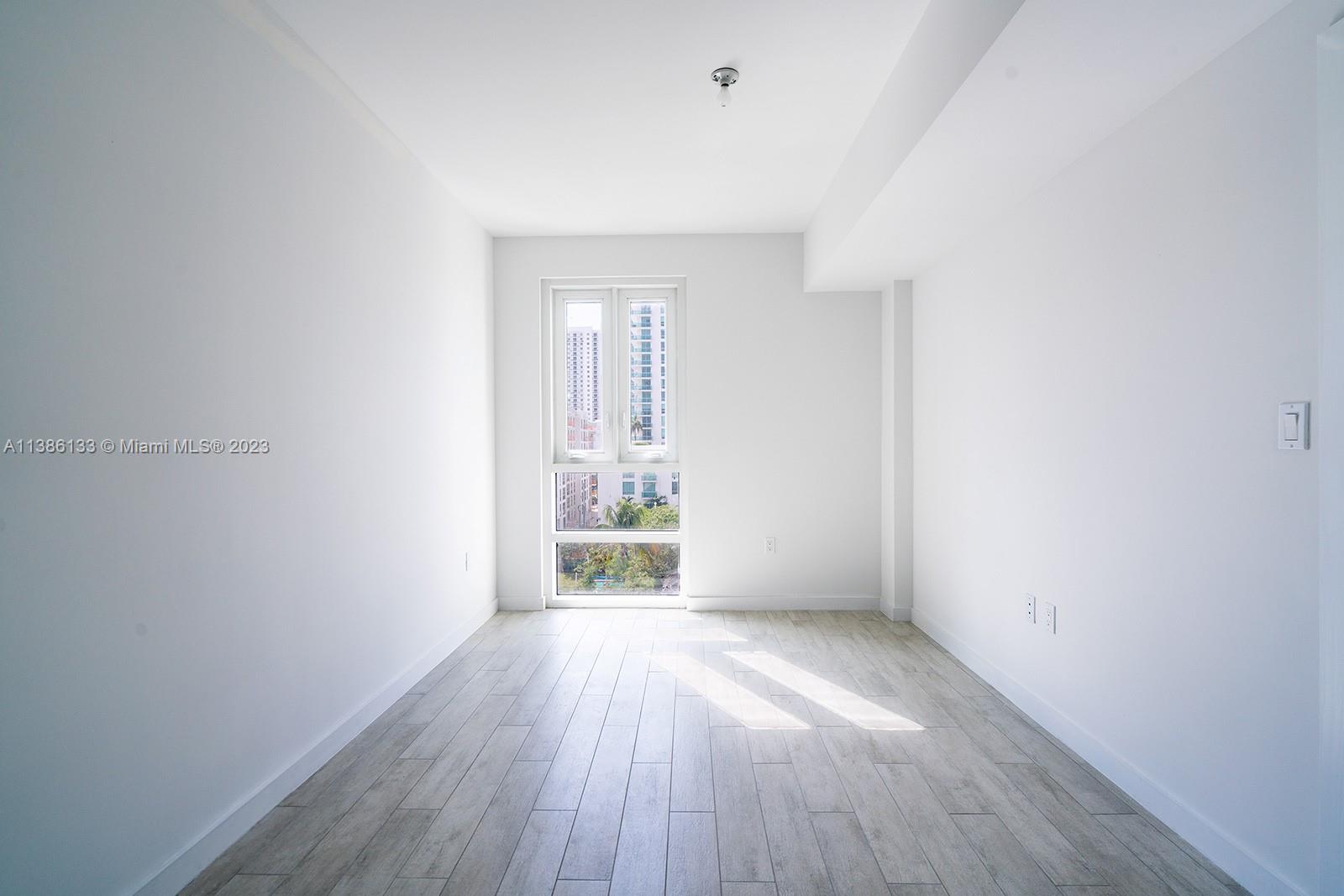 321 Northeast 26th Street, Unit 615 Miami, FL 33137 - Photo 9 of 15 wooden floor in an empty room with a window