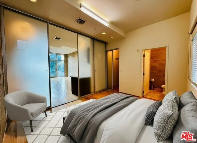 a bedroom with a bed and wooden floor