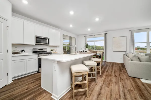 a kitchen with sink a microwave and cabinets