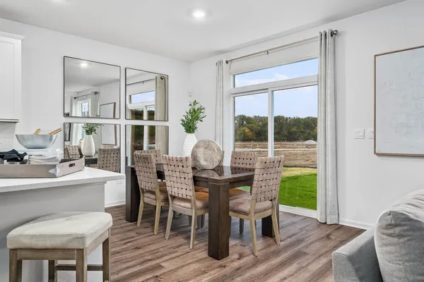 a dining room with furniture a rug and a floor to ceiling window