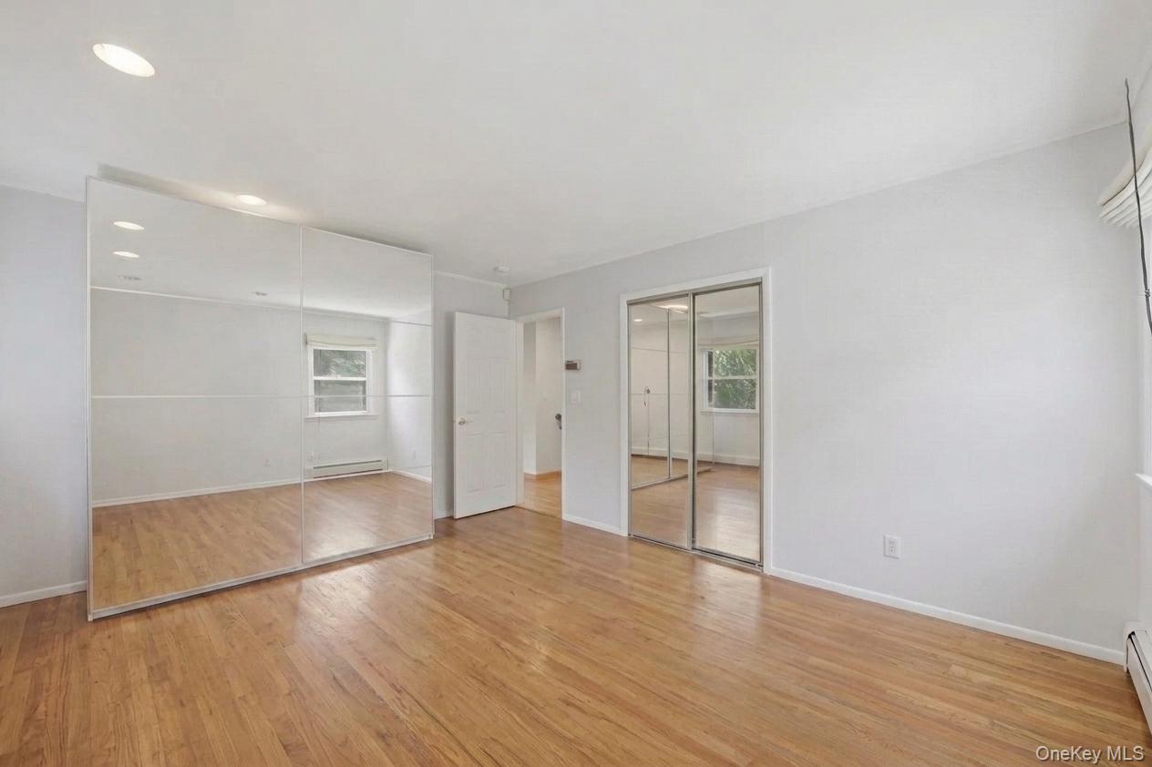 29 Montrose Road Yonkers, NY 10710 - Photo 12 of 39 Primary bedroom with hardwood flooring throughout featuring recessed lighting and mirrored closet doors