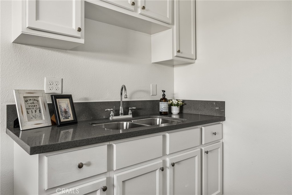 6725 Perry Road Bell Gardens, CA 90201 - Photo 23 of 40 a kitchen with granite countertop a sink and cabinets