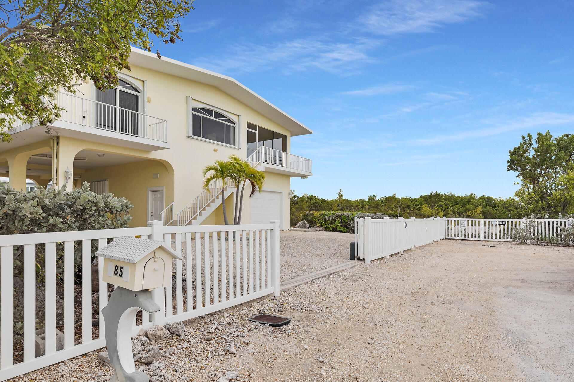 85 Ocean Shores Drive Key Largo, FL 33037 - Photo 4 of 77 a front view of a house with mountain view and wooden fence