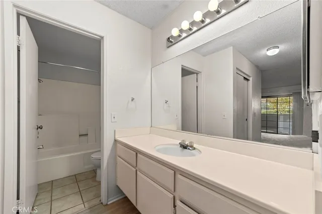 a bathroom with a tub a sink and a large mirror