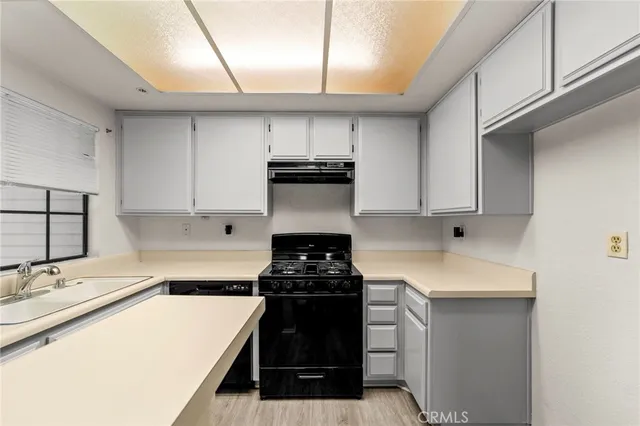 a kitchen with a sink and white cabinets