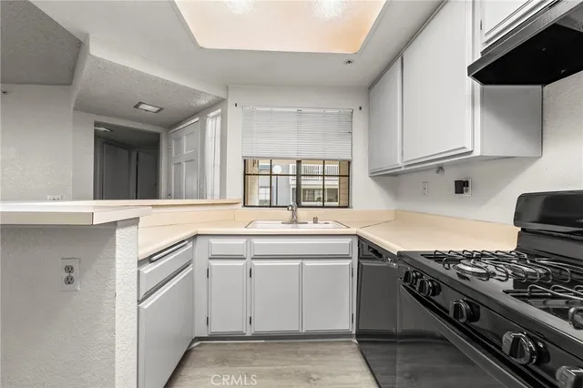 a kitchen with a sink stove and cabinets