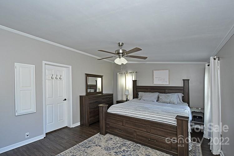 216 Jones Road Mocksville, NC 27028 - Photo 19 of 48 a bedroom with a large bed and a chandelier