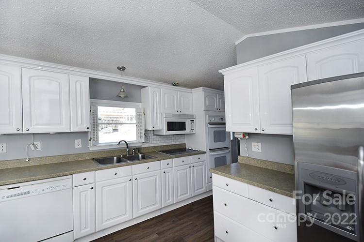 216 Jones Road Mocksville, NC 27028 - Photo 33 of 48 a kitchen with granite countertop white cabinets and white appliances