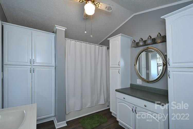 216 Jones Road Mocksville, NC 27028 - Photo 38 of 48 a bathroom with a granite countertop bathtub a mirror and a shower