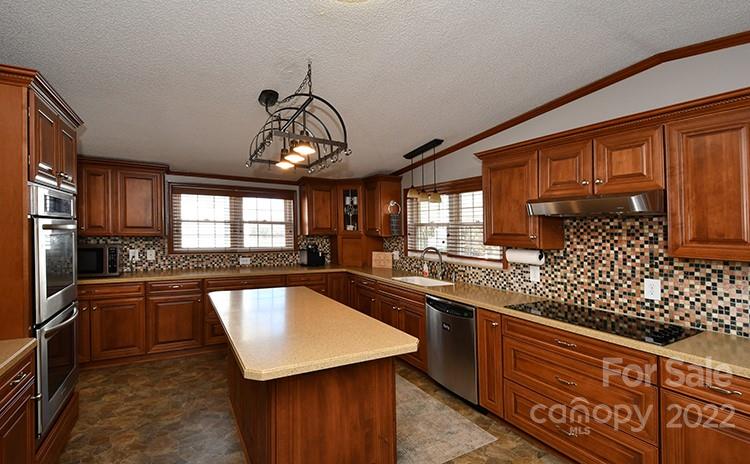 216 Jones Road Mocksville, NC 27028 - Photo 9 of 48 a kitchen with stainless steel appliances granite countertop sink stove top oven and cabinets