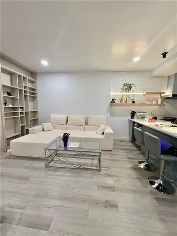 a living room with furniture and a gym machine with rug