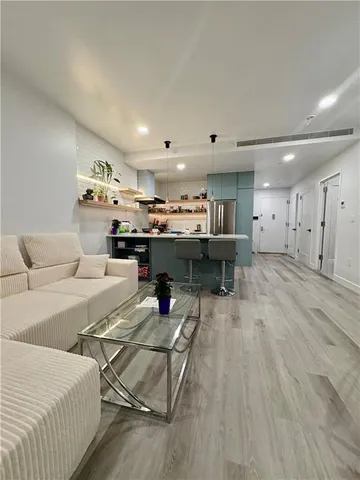 a living room with lots of furniture and kitchen view