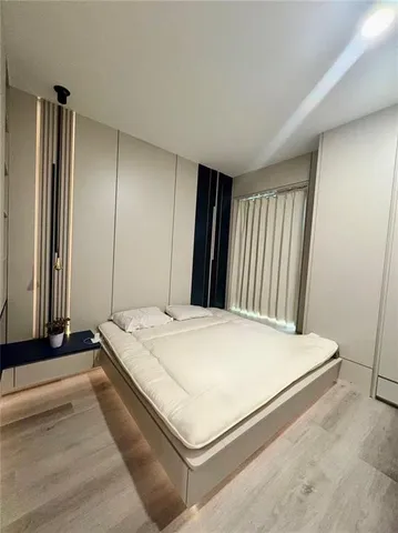 a bed sitting in a spacious bedroom next to a window and dresser