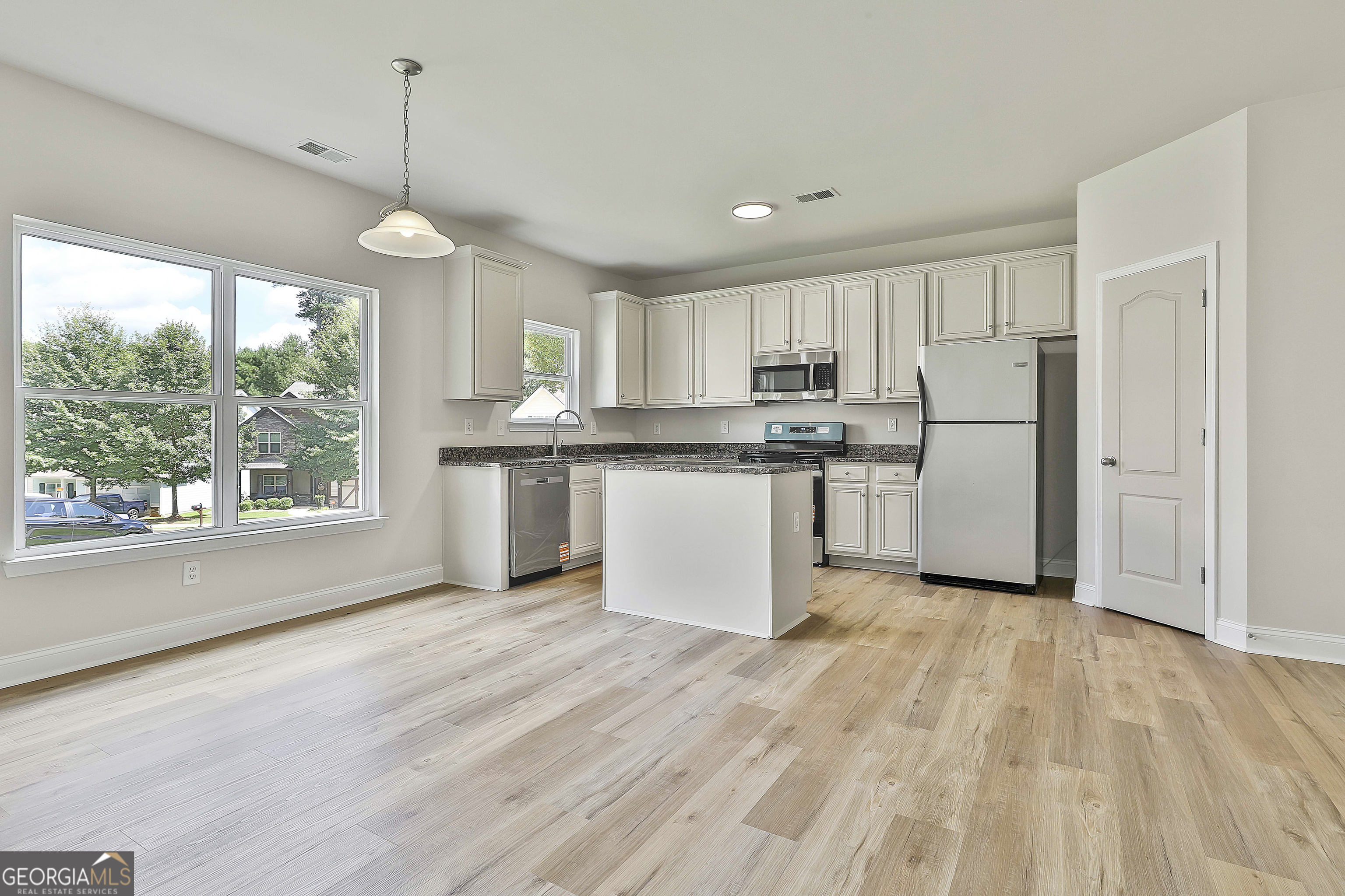 28 Fox Ridge Drive Newnan, GA 30265 - Photo 17 of 47 a kitchen with stainless steel appliances granite countertop a sink a stove a refrigerator and island with wooden floor
