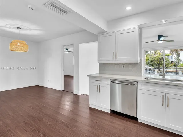 a kitchen with a refrigerator stove and white cabinets