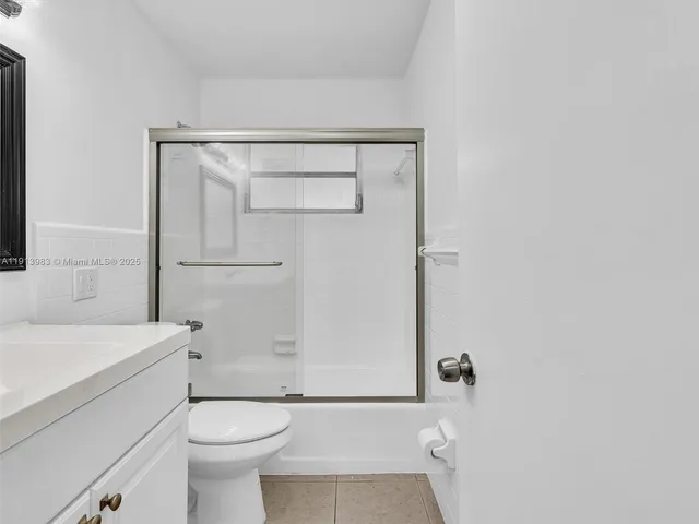 a bathroom with a toilet a sink a mirror and a shower