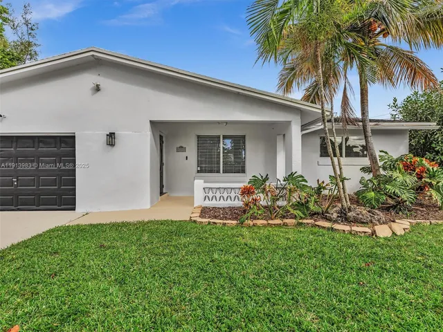 a front view of a house with a garden and plants