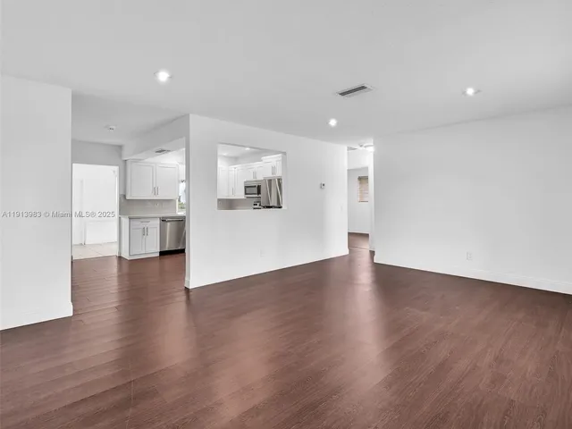 a view of a living room a wooden floor and a window