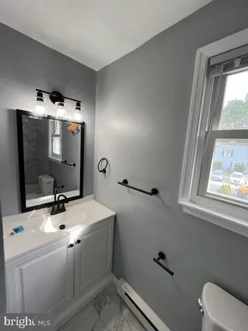 a bathroom with a sink toilet and mirror