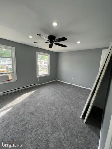an empty room with windows and ceiling fan
