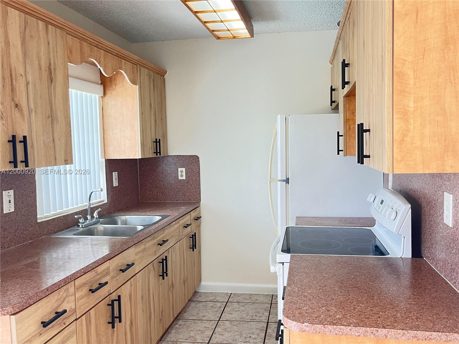 20341 Southwest 117th Avenue Miami, FL 33177 - Photo 4 of 12 a kitchen with stainless steel appliances granite countertop a sink stove and refrigerator