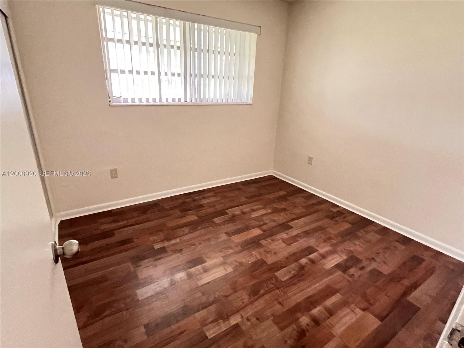 20341 Southwest 117th Avenue Miami, FL 33177 - Photo 7 of 12 an empty room with wooden floor and windows