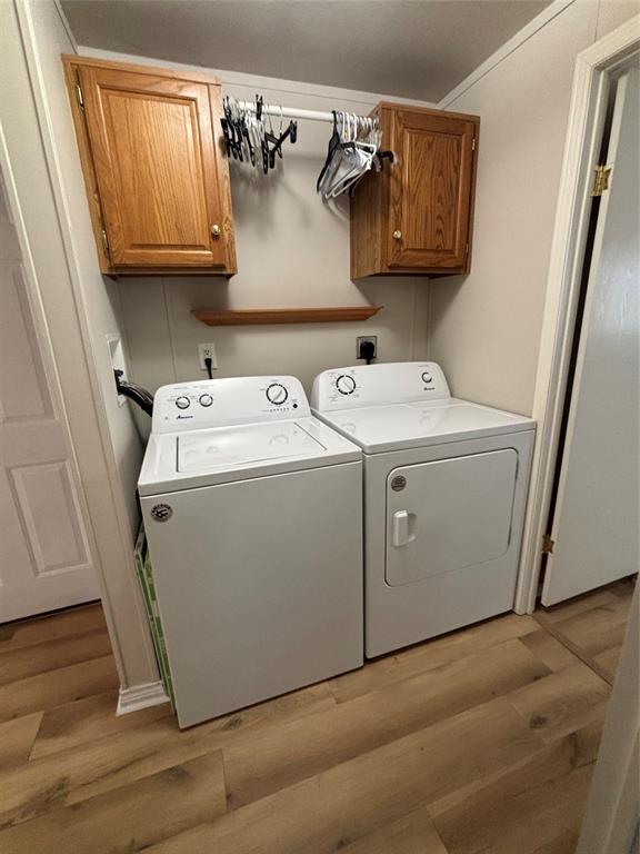 206 Holiday Rambler Drive Whitney, TX 76692 - Photo 28 of 28 Dedicated laundry space featuring wood-finish flooring, overhead wood cabinetry, and a wall-mounted drying rod